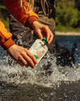 Person showing a pouch of Rigby Salmon dog Treat with nature background