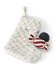 White textured stocking with a red and white candy and green ornament on a white background