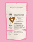 Dog treat package with heart-shaped cookie and text on a pink background