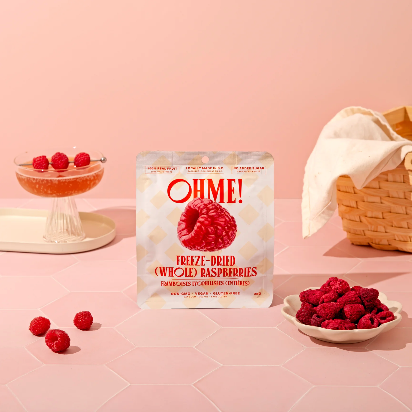 OHME! freeze-dried raspberries packaging on a pink background with raspberries around
