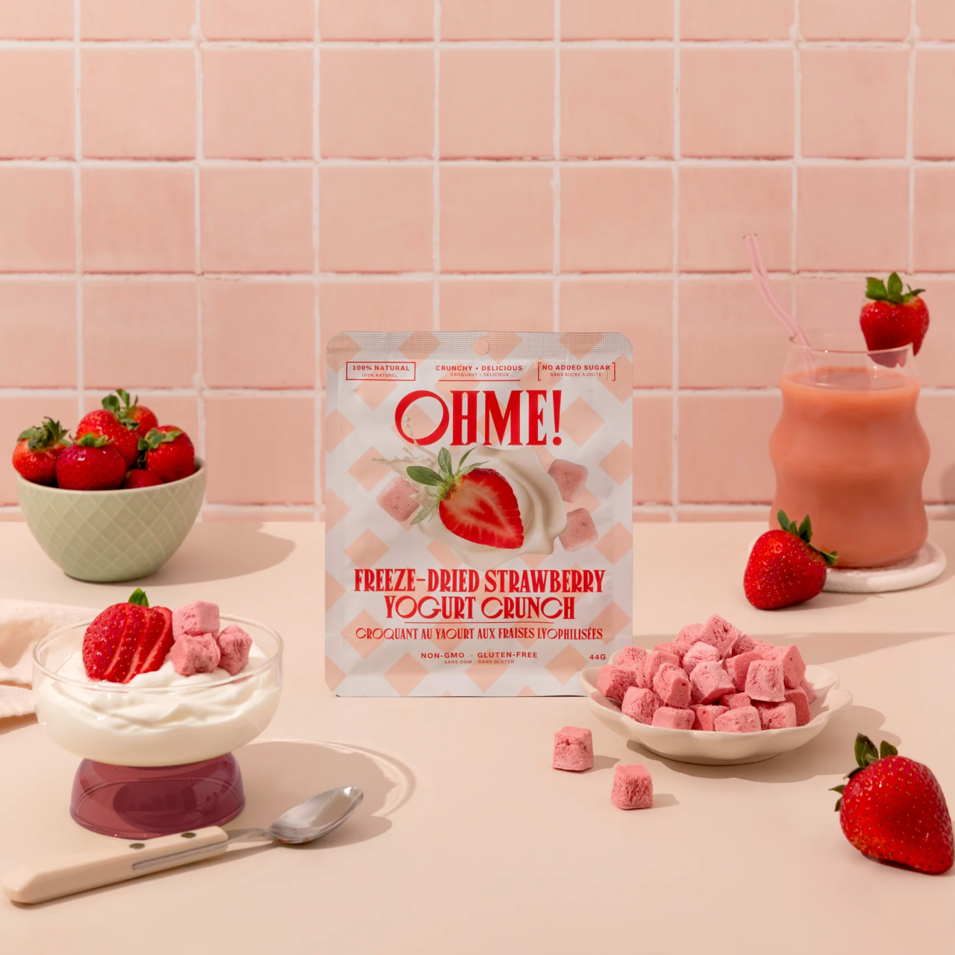 OHME! freeze-dried strawberry yogurt crunch packaging with strawberries and yogurt on a pink tiled background