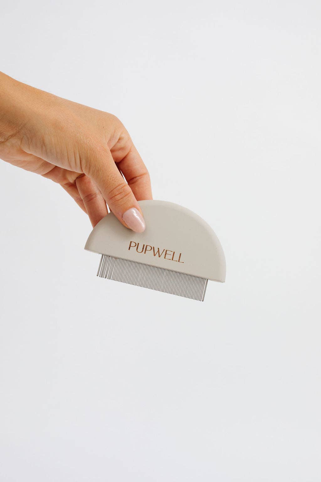 A hand holding a white pet grooming comb with the brand 'PUPWELL' inscribed on it against a white background.
