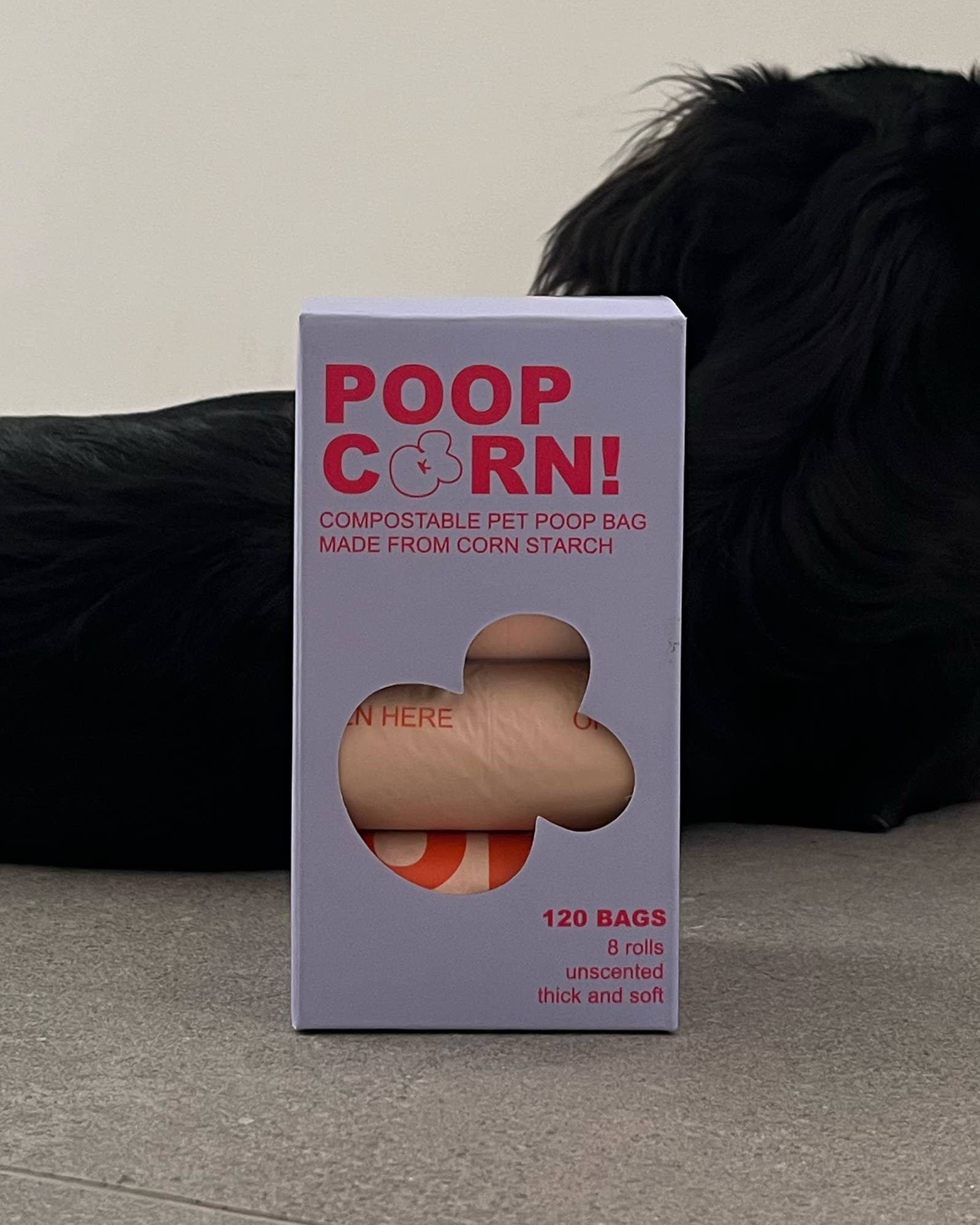 Box of Poop Corn compostable pet poop bags with a dog in the background