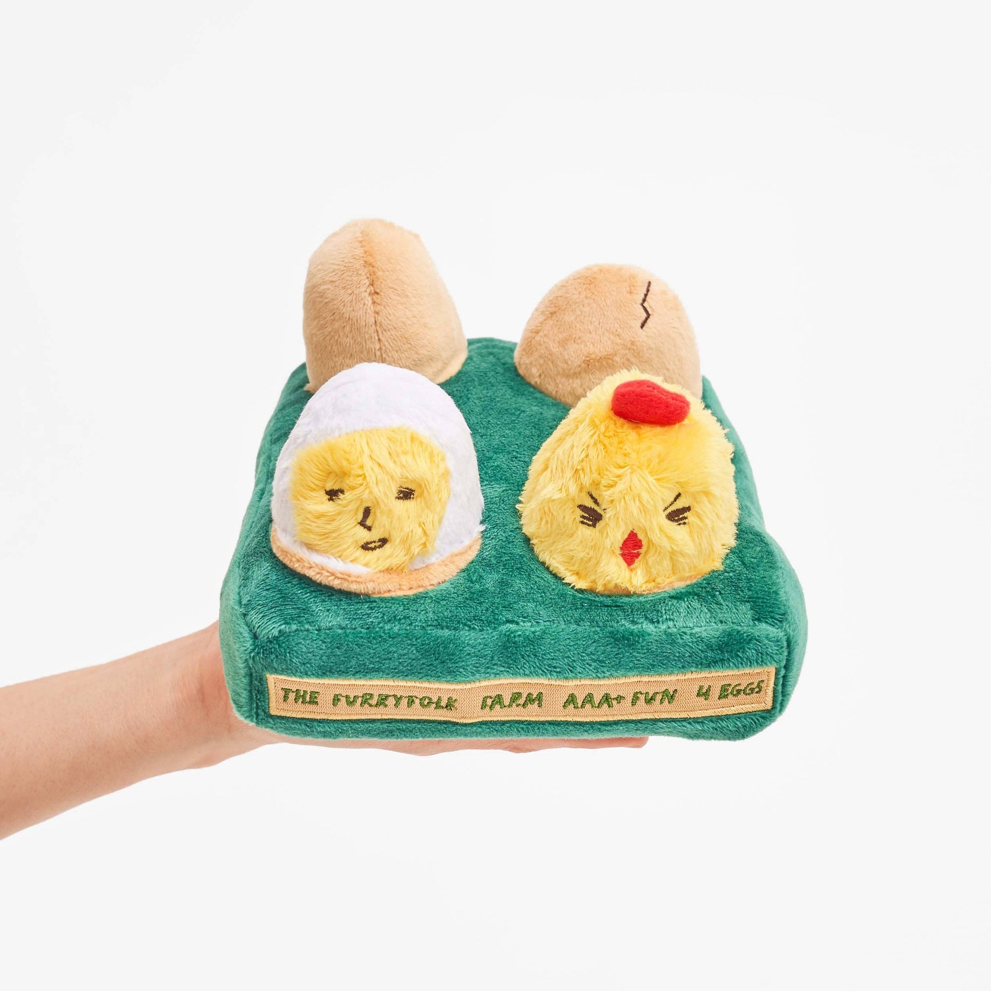 A plush dog toy resembling two stylized eggs with faces, in green fabric, with a squeaker inside. the furry folks farm aaa+ fun 4 eggs